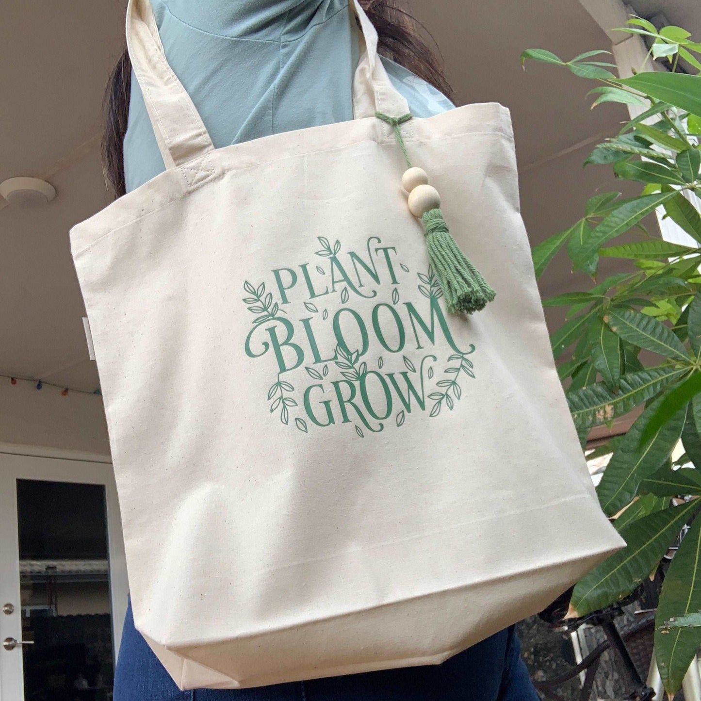 a tote bag with design that said in green color plant bloom grow