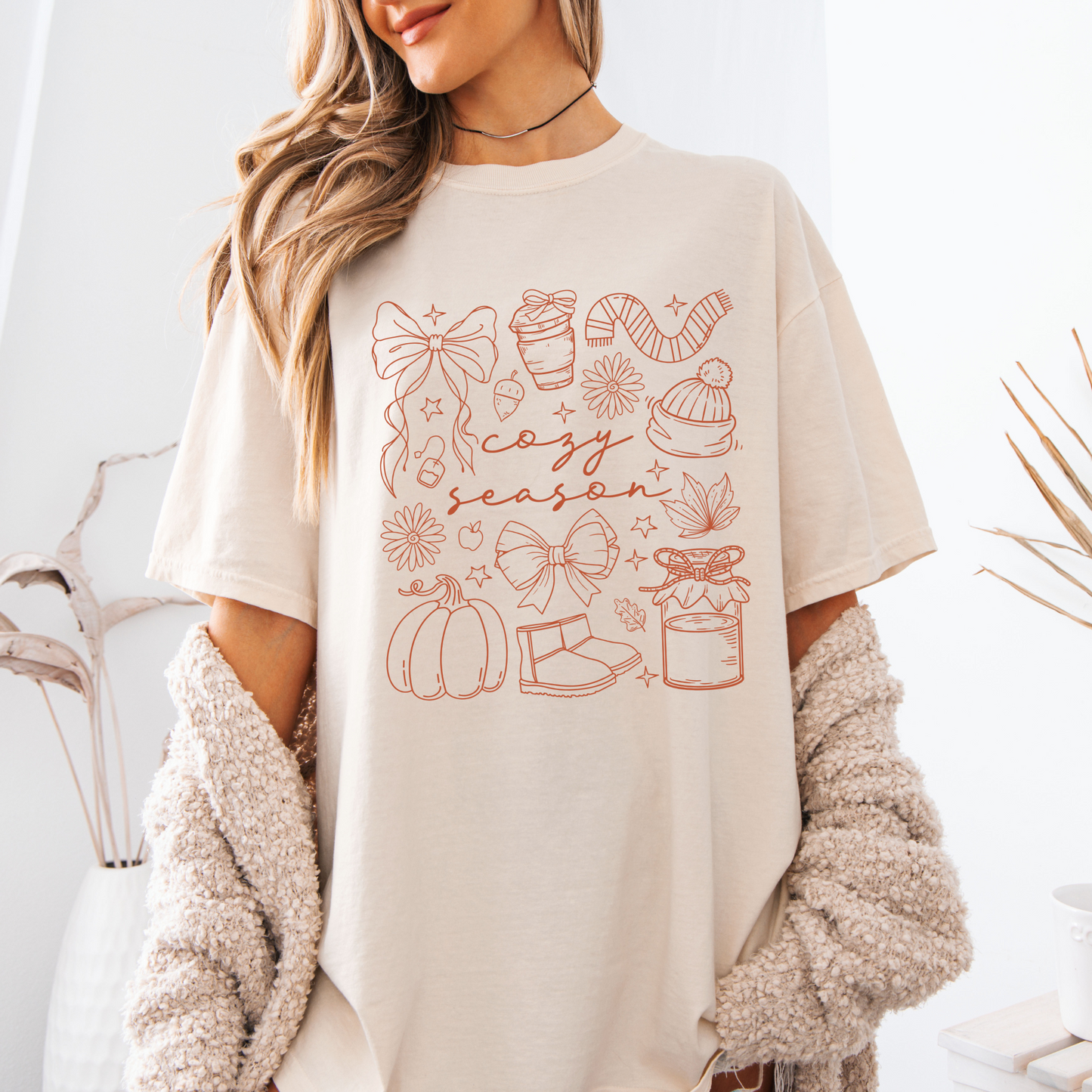 Person wearing a beige t-shirt with colorful text and graphics on a white background
