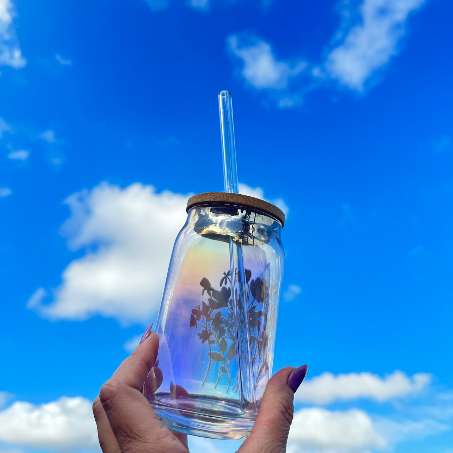 hand holding an holographic cup with the sky background