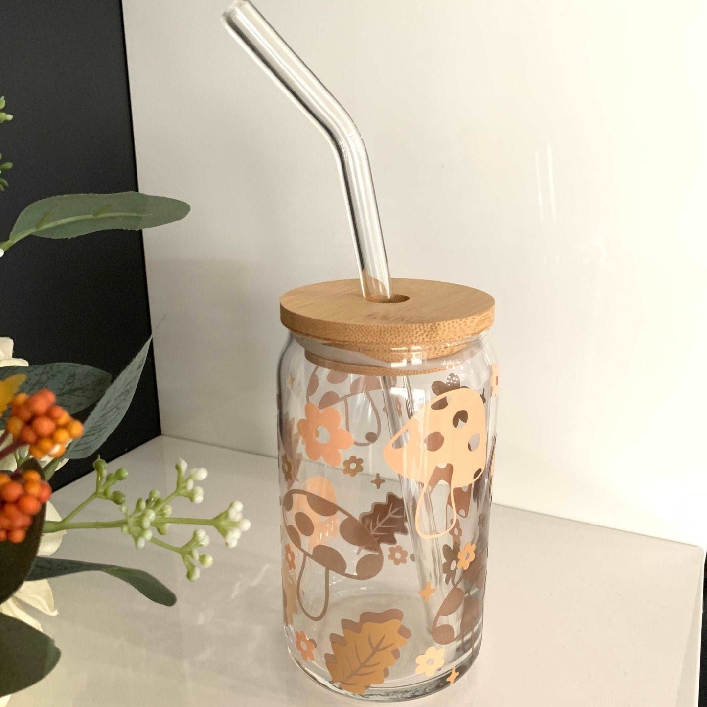 Natural Mushroom Glass tumbler with a wood lid and straw standon a white background