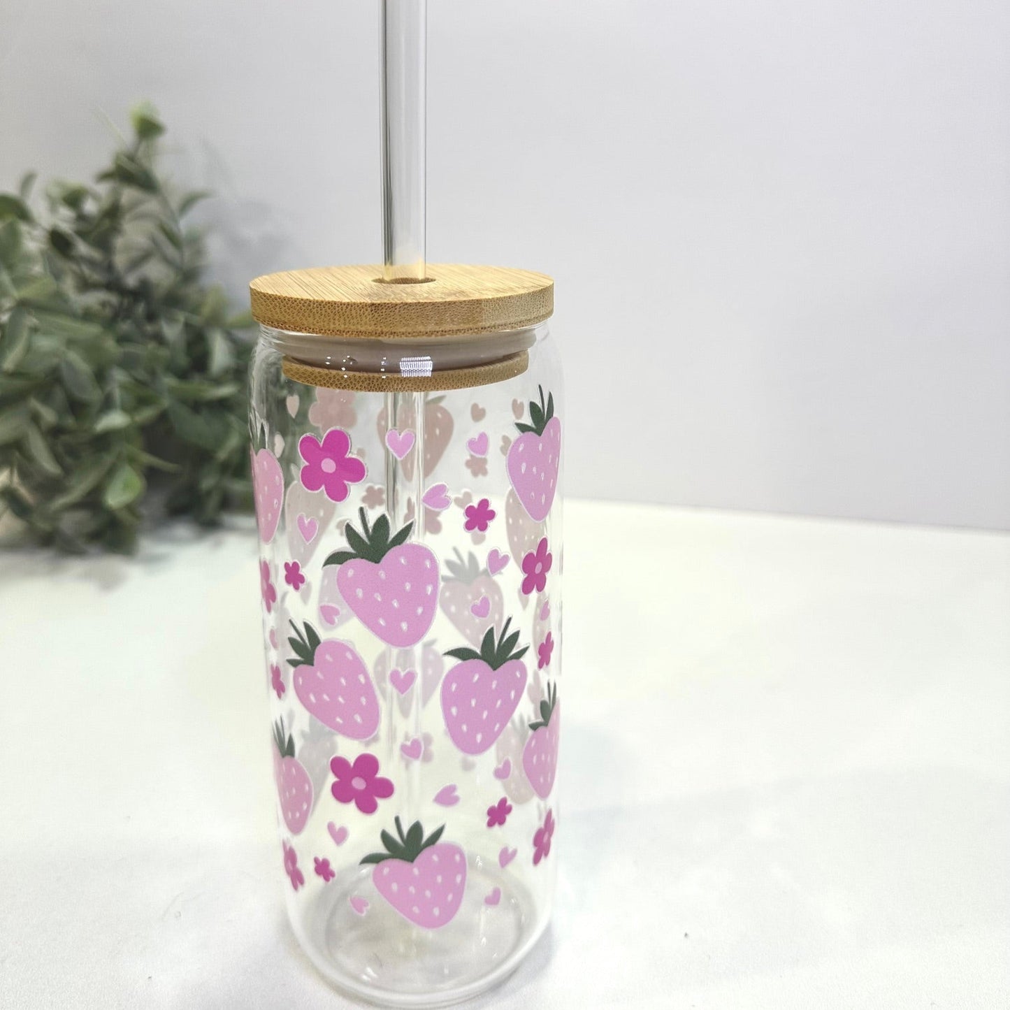 Tumbler with strawberry and flowers pattern on a white surface