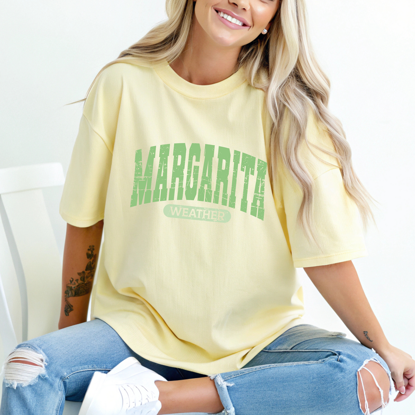 a women wearing a light yellow shirt with a "margarita weather" text in lime green color r