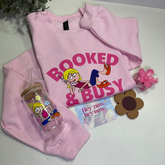 Pink sweatshirt  with cartoon character Lizzie design, a cup, hey now hey now greeting card, a flower clip and a flower coaster  on a white surface