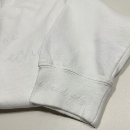 wrist of white sweatshirt that said i said yes in embossed design