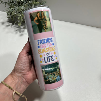 a hand holding a custom tumbler with friends photos