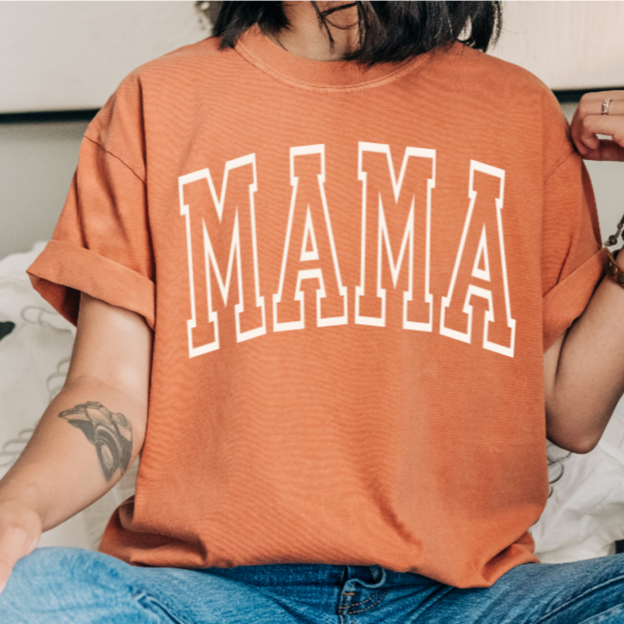Person wearing an yam t-shirt with 'MAMA' printed on it.
