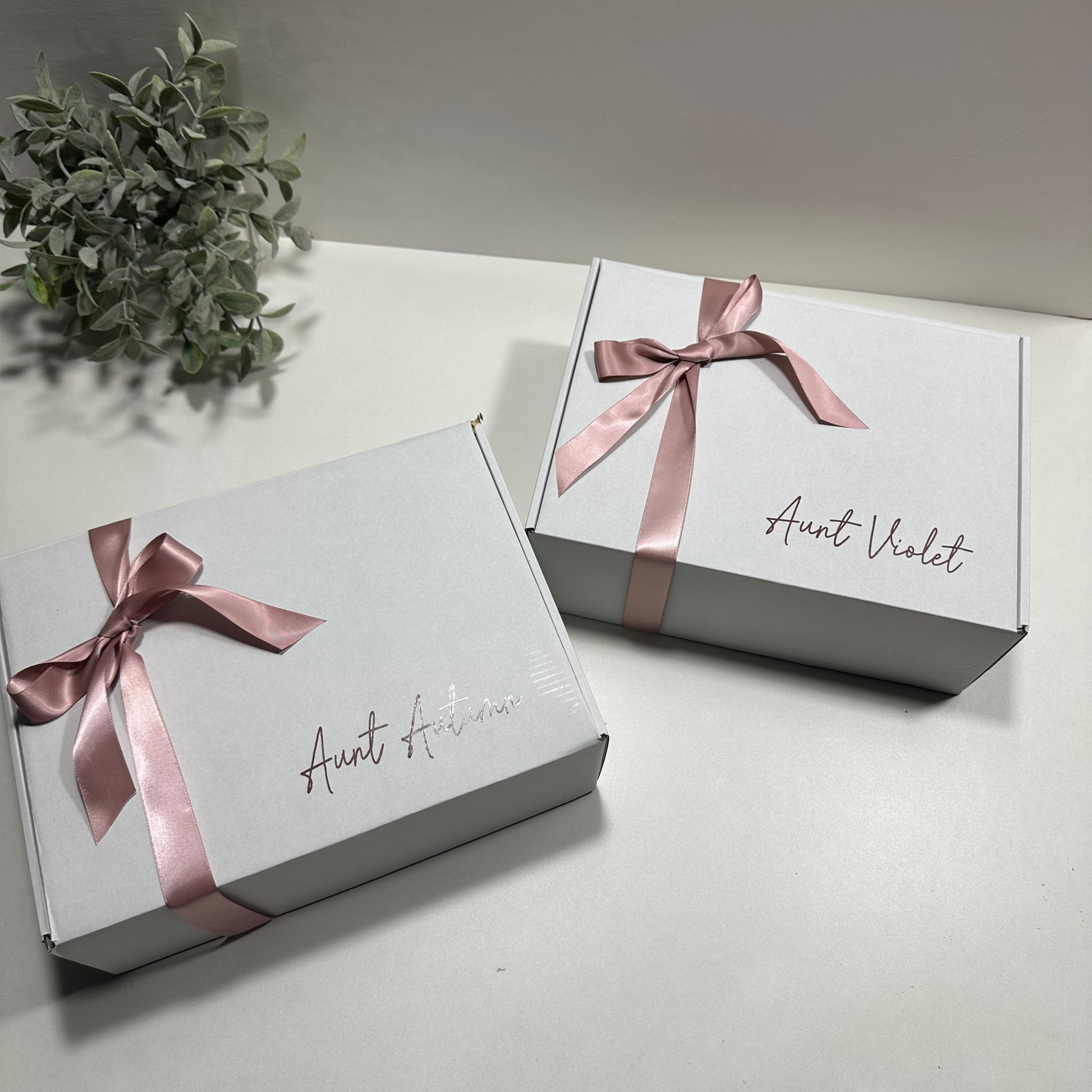 2 white box personalized with pink bow with aunt name on it
