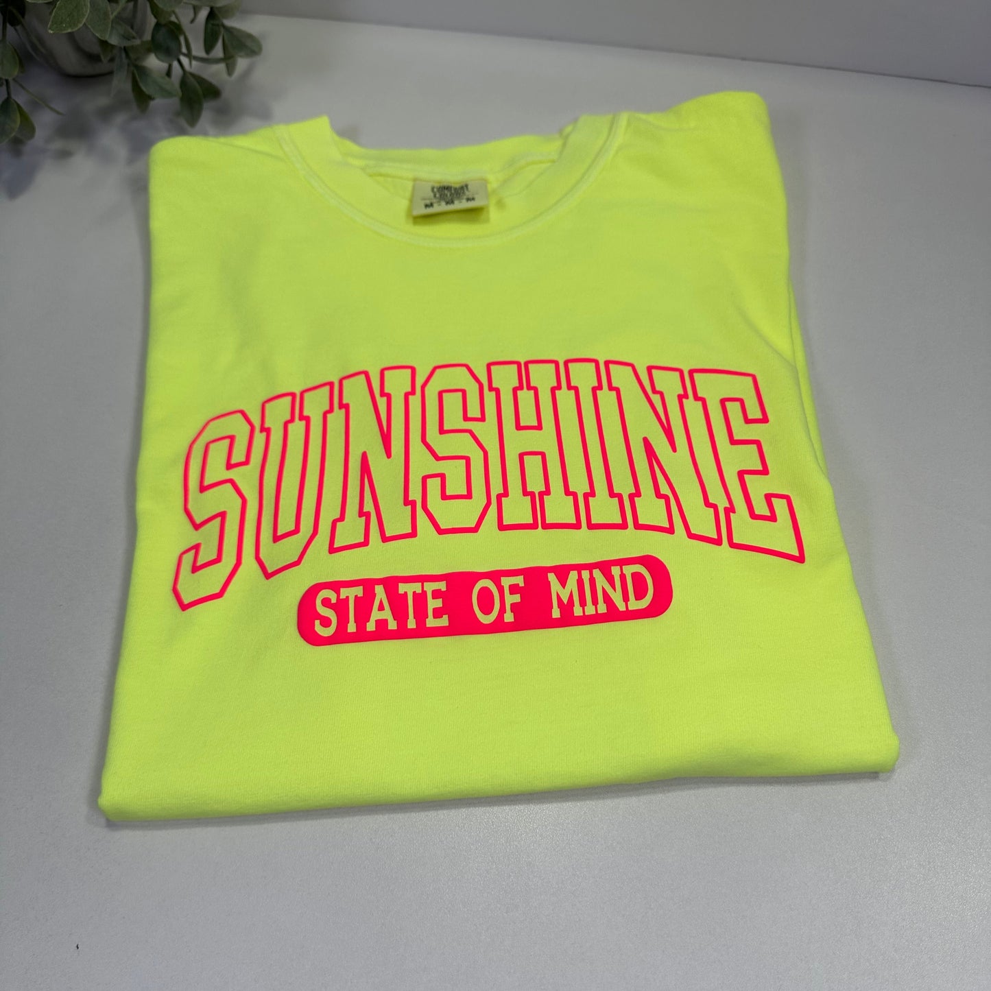 neon Yellow t-shirt with a neon pink text on a gray background