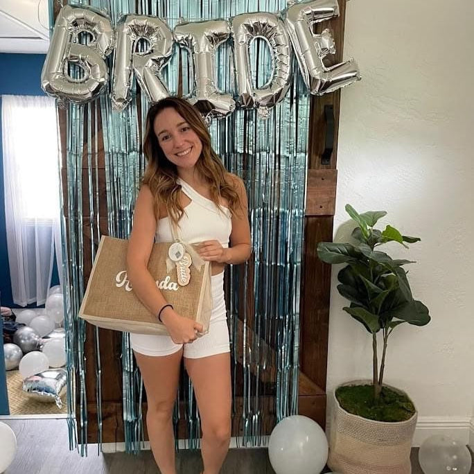 a bride with a personalized jute bag with her name